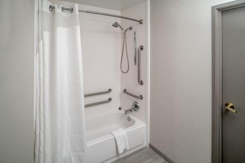 a bathroom with a shower with a white shower curtain at Holiday Inn Express - Charleston/Kanawha City by IHG in Charleston