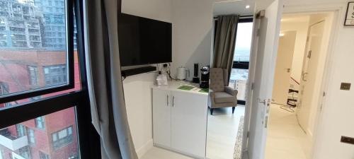 a living room with a tv and a window at Phoenix Heights in London