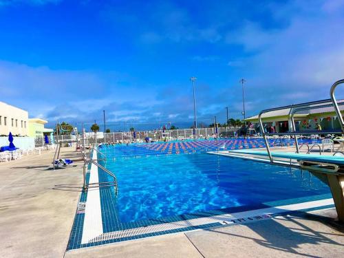 a large swimming pool with blue water and chairs at SW Florida Luxury Modern Retreat, King Bed Suite , Close to Beaches / Golfing / Fishing / Air Ports , 2023 Built in Rotunda-West