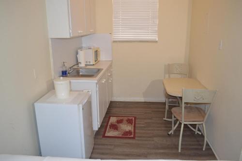 a small kitchen with a sink and a table at Island House South Beach in Miami Beach