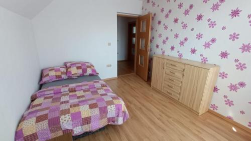 a bedroom with a bed with a purple blanket at Apartament Marzanna in Spytkowice