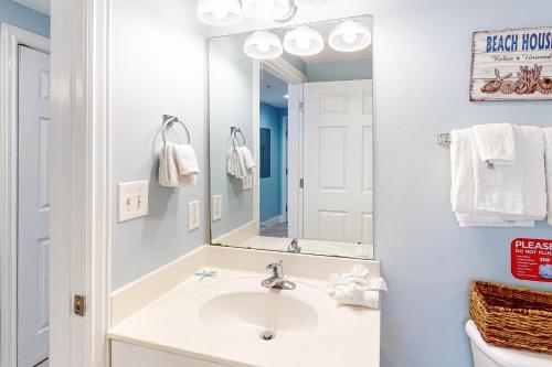 a bathroom with a sink and a mirror at Majestic Beach Resort Tower 2- 1903 in Panama City Beach