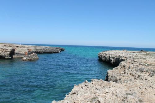 a body of water with rocks in the water at Hotel Victoria in Torre Santa Sabina