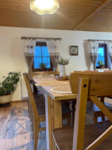 a dining room with a wooden table and chairs at Chalupa U rybníčku in Krásná Lípa