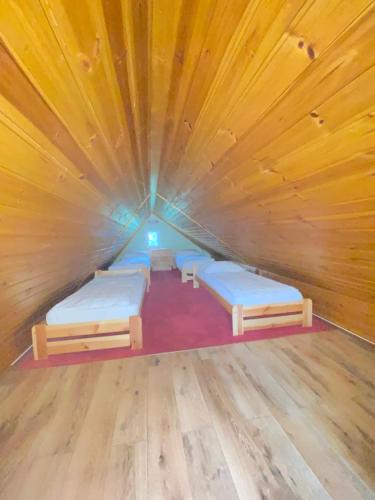 a room with four beds in a wooden room at Chalupa U rybníčku in Krásná Lípa