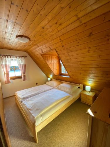 クラースナー・リーパにあるChalupa U rybníčkuの木製天井のベッドルーム1室(大型ベッド1台付)