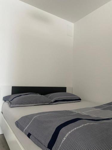 a bedroom with a bed with a white wall at Apartment Vrbani in Zagreb