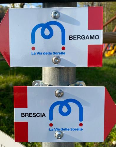 two signs on top of a pole at Da Agostino, la casa del latte in Costa di Mezzate