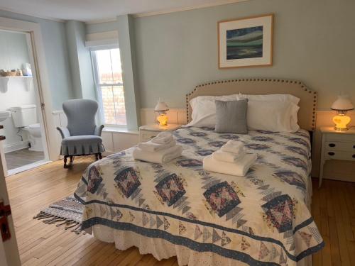 1 dormitorio con 1 cama con toallas en The Cornish Inn, en Cornish