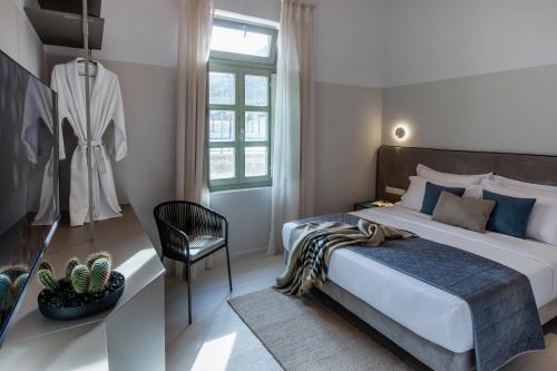 a bedroom with a large bed and a chair at Octavia Rooms in Korinthos