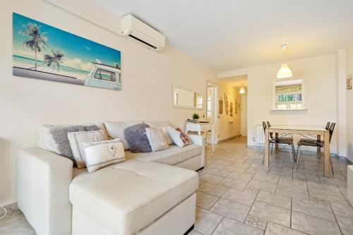 a living room with a white couch and a table at Hauzify I Apartament Bòvila Mar in S'Agaro