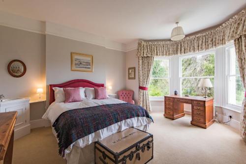 een slaapkamer met een bed, een bureau en een raam bij Burleigh House by Bloom Stays in Charing