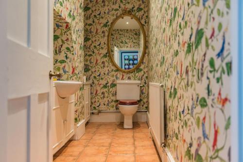 a bathroom with a toilet and a mirror at Burleigh House by Bloom Stays in Charing