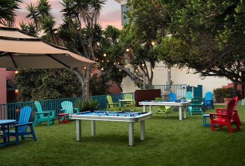 a group of tables in a yard with colorful chairs at La Jolla Cove Suites in San Diego