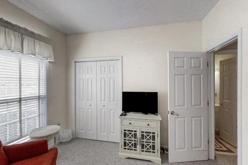 a living room with a tv and a door at Scotch Broom E-104 in Little River