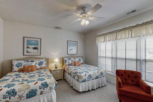a bedroom with two beds and a ceiling fan at Scotch Broom E-104 in Little River