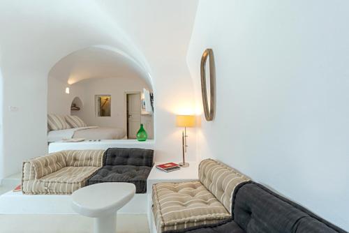a living room with a couch and a bed at Crown of Fira in Firostefani
