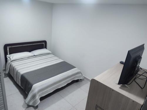 1 dormitorio con 1 cama y TV de pantalla plana en Hotel torre 15, en Bogotá