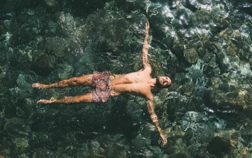 a man is swimming in the water at La Jolla Cove Suites in San Diego
