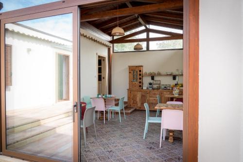 a glass door leading into a dining room with a table at La Manica Rooms in Milazzo
