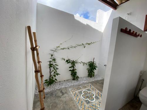 bagno con pareti bianche e pavimento piastrellato. di Os Navegantes - Casa Mar a Amontada