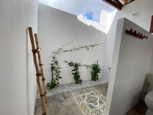 baño con paredes blancas y suelo de baldosa. en Casa Mar - Os Navegantes, en Amontada