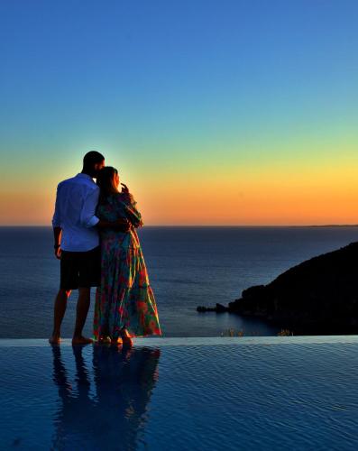 a man and a woman standing on the edge of the ocean at PARGA Villas Collection in Parga