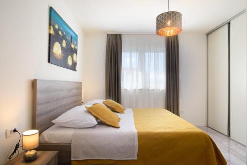 1 dormitorio con 1 cama con sábanas amarillas y ventana en Villa Barbara & Zoran with heated swimming pool en Seget Vranjica
