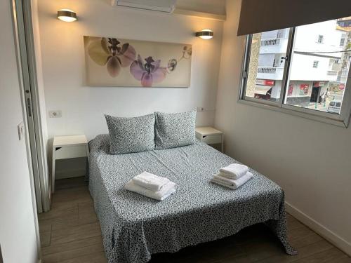 um pequeno quarto com uma cama com duas toalhas em Habitaciones IFAE em Alcalá