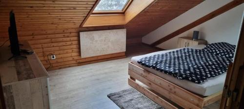 una camera da letto con letto in una camera in legno di 3 Zimmer Dachgeschosswohnung a Bayreuth