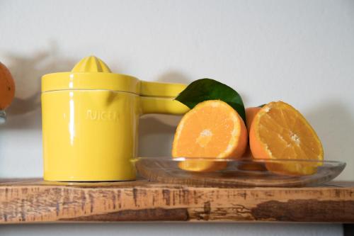 a glass bowl of oranges on a table with a juicer at B&B La Manica in Milazzo