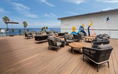 a deck with couches and tables and chairs at La Jolla Cove Suites in San Diego