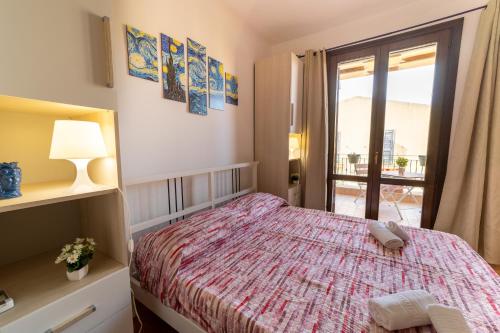 a small bedroom with a bed and a window at Casa al Vicolo 99 in Birgi Vecchi