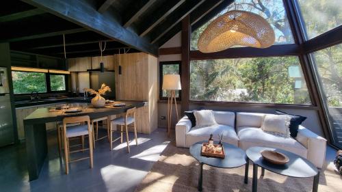 cocina y sala de estar con sofá y mesa en Haus del Arroyo - Andarlibre en San Martín de los Andes