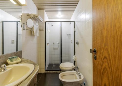 a bathroom with a toilet and a sink and a shower at Ritter Hotéis in Porto Alegre