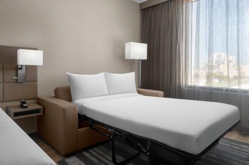 邁阿密的住宿－AC Hotel by Marriott Miami Dadeland，一间设有窗户的酒店客房内的一张白色床