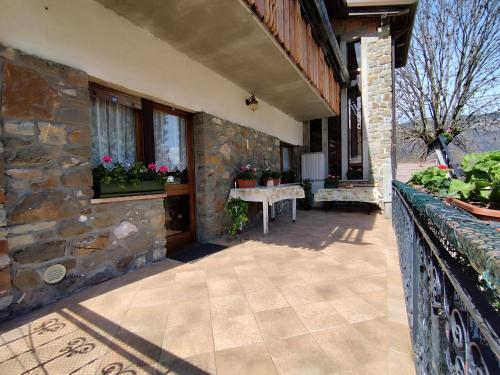 a stone house with a patio with a table on a porch at Villa Salagona in Laggio