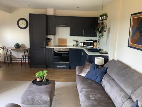 uma sala de estar com um sofá e uma cozinha em Bonny Vista em Inverness