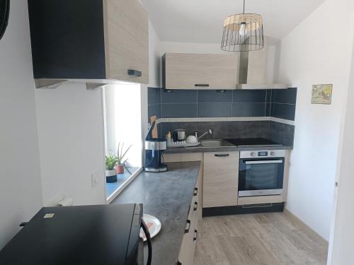 a kitchen with a sink and a stove top oven at Charmante maison en pierres in Langon