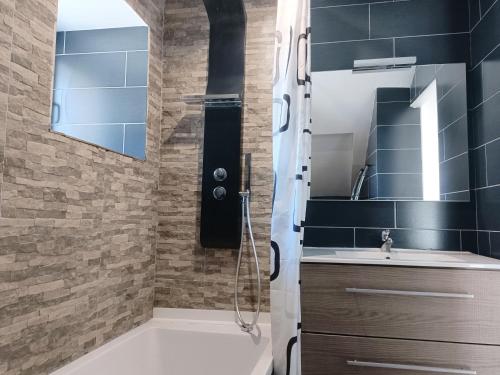 een badkamer met een wastafel en een spiegel bij Charmante maison en pierres in Langon