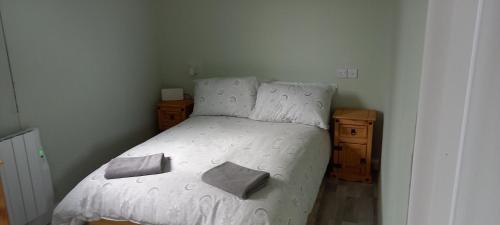 a bedroom with a white bed with two pillows on it at Grenada Garden Lodges in Ingoldmells