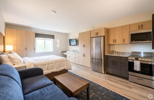 a living room with a couch and a bed and a kitchen at Residences at Solomon Pond in Marlborough