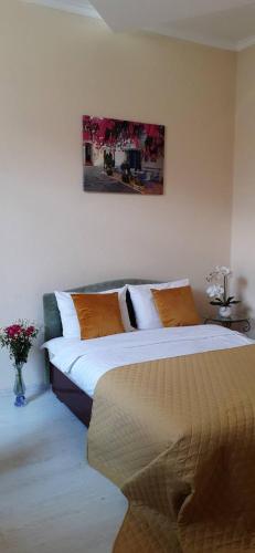 a bedroom with two beds and a painting on the wall at Центрові апартаменти in Ivano-Frankivsʼk