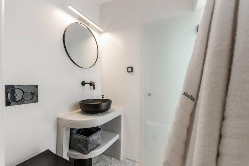 a bathroom with a sink and a mirror at FK Luxury Suites - Orkos Beach in Mikri Vigla