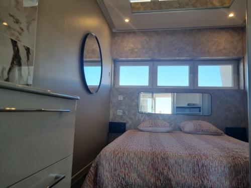 um quarto com uma cama e um espelho em Capricia Port Nature 2-Coursives -Vue mer em Cap d'Agde