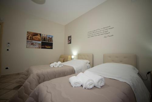 a room with two beds with towels on them at B&B La Terrazza Degli Scrittori in Racalmuto