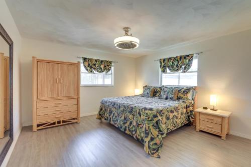 a bedroom with a bed and a dresser and two windows at Sarasota House with Private Pool - 4 Mi to Beach! in Sarasota
