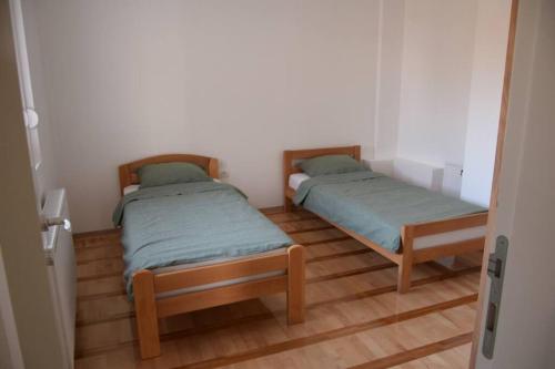 - 2 lits dans une petite chambre dotée de parquet dans l'établissement Fruška sweetie 1, à Sremska Kamenica