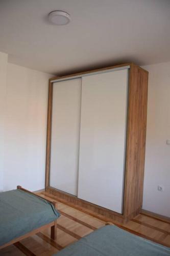 Cette chambre dispose d'une porte coulissante en verre. dans l'établissement Fruška sweetie 1, à Sremska Kamenica
