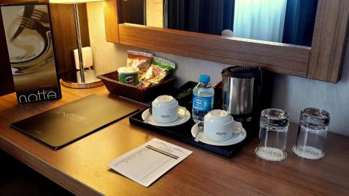 a table with a tray with cups and a coffee maker at Notte Hotel in Ankara